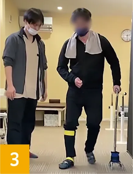 一歩ずつ足取りを進め前進する利用者と寄り添う作業療法士